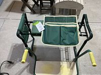 Top view showing garden kneeler/seat with green padded cushion, yellow grip handles, and attached storage pouch with compartments.