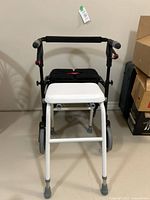 Front view of the white stool seat placed in front of the Nexus walker.