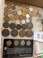 Overview of loose coins and sealed Morgan Mint boxed set displayed in cardboard tray