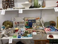 Wide view of sewing supplies including scissors, needles, button boxes, threads, tracing paper, and a decorative tin box