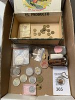 Overview of lot contents including tokens, coins and paper tickets in a box