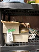 Storage container holding a thick stack of vintage postcards and cards.