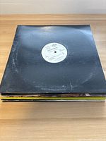 Stack of 10 vinyl singles showing black, white, and plain sleeves, close up of label reading 'Mystikal'