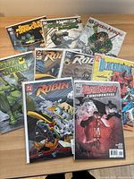 Comic book lot featuring Green Arrow, Green Hornet, Robin, and Batman Confidential series on display on a wooden floor.