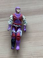 Front view of a vintage G.I. Joe Nemesis Enforcer action figure showing purple and beige coloring with red vest.
