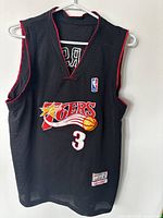 Front view of the black Mitchell & Ness Philadelphia 76ers Allen Iverson jersey with number 3 and NBA logo patch.