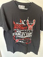 Front view of black Molson Canadian T-shirt with white and red hockey Stanley Cup Championship themed graphic.