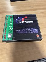 Front cover of the PlayStation 1 Gran Turismo Greatest Hits video game case showing the logo and rating.