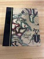 Closed view of binder with vintage map cover showing black fabric spine