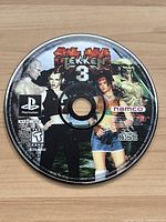 Top of Tekken 3 game disc showing label side with game title and artwork.