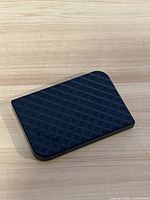 Image of the top textured grid pattern surface of the black Verbatim external hard drive.
