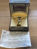 Angle view showing watch in box with brand and guarantee details.