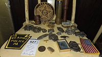Overall lot displayed on shelf, featuring wooden plaque, baton, badges, patches