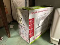 Cardboard box of Singer Tradition 2277 sewing machine, showing product branding and model number.