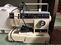 Front view of Singer sewing machine with power cord and foot pedal.