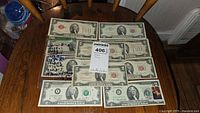 Nine $2 silver certificates arranged on table showing fronts