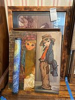 Photo showing collection of framed and unframed prints and posters, including Big Eye style prints, a vintage mother and child print, and a rolled Starry Night poster