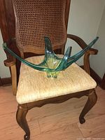 Full view of centrepiece placed on a cane-back wood chair to indicate overall shape and scale