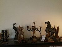 Wide view of entire lot showing multiple carved wooden figurines including a horse, deer with large antlers, peacock, small animals, and a multi-armed candle holder.