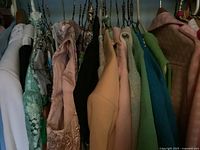 Wide view of assorted women’s clothing on a rack showing a mix of jackets and dresses