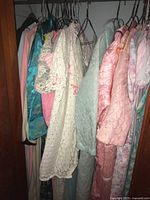 View of various hanging sleepwear: pastel quilted, lace and floral robes