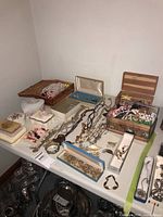 Overview of table showing multiple decorative boxes and assorted jewelry items spread out