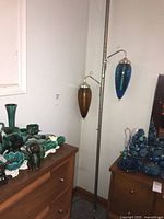 Full view of telescoping pole lamp with two glass cone shades positioned on either side