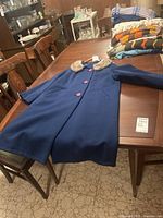 Full view of the vintage wool coat laid flat on a table, showing overall good condition and design.