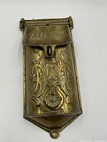 Front view of brass mail box showing embossed "MAIL BOX" flap and decorative engraving