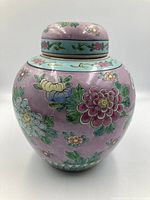 Front angled view of the large lavender colored ceramic lidded ginger jar featuring intricate floral and green leaf designs.