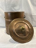 Front view of the copper pot with the lid placed in front