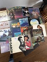 Top view of 17 vinyl LP records arranged to display album cover art, showing various artists and albums.