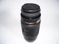 Top view of Canon EF 70-210mm lens with front lens cap attached, showing zoom and focus rings and distance scale window.