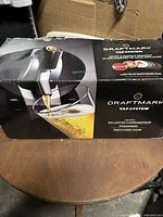 Photo of Draftmark tap system box showing tap and glass of draft beer.