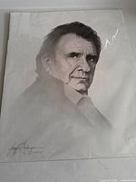 Full black and white portrait print of Johnny Cash showing artist signature on bottom left corner.