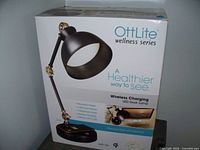 Boxed OttLite Wellness Series Wireless Charging LED Desk Lamp showing product image, brand, and features.