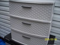 Front view of plastic drawer unit showing three drawers with silver handles and woven pattern design