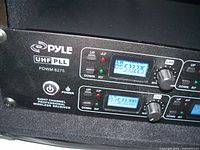 Close view of Pyle UHF PLL model PDWM 8275 rack-mount wireless receiver unit with digital displays showing frequencies and control knobs.