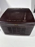 Closed view of a brown RCA vintage record player with speaker grille and control buttons.