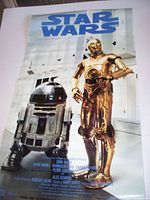 Photo of a Star Wars promotional poster with C-3PO and R2-D2 characters, folded and laid flat on a surface.