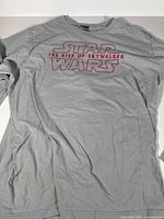 Front view of one grey Star Wars The Rise of Skywalker t-shirt with red outline text logo