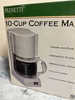 Box front showing brand and features of the coffee maker.