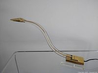 Side view showing the full length and graceful S-curve of the lucite and brass lamp with brass base and head.