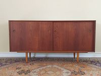 Frontal view showing entire credenza with two sliding doors and tapered legs.