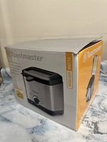 Photo of the unopened Toastmaster deep fryer box showing the product image and model details on the packaging.