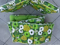 Photo showing three cushions arranged together revealing floral pattern and solid green tufted seating surface.