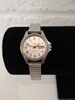 Front view of vintage Citizen watch showing white dial with day-date display and stainless steel stretch bracelet.