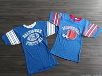 Both jerseys laid flat showing front: Baltimore Football and Montreal helmet designs