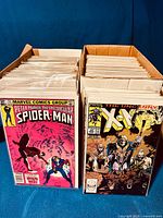 Two full boxes of comics standing side by side, front covers visible