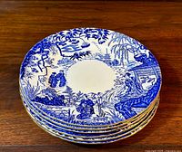 Stack of six Mikado pattern plates on wood surface